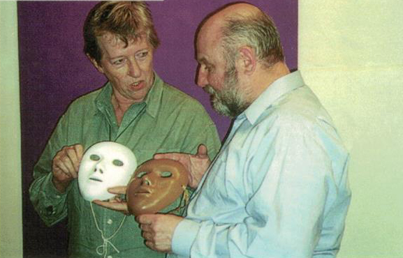 Sue and Gordon holding masks while working together in a workshop.