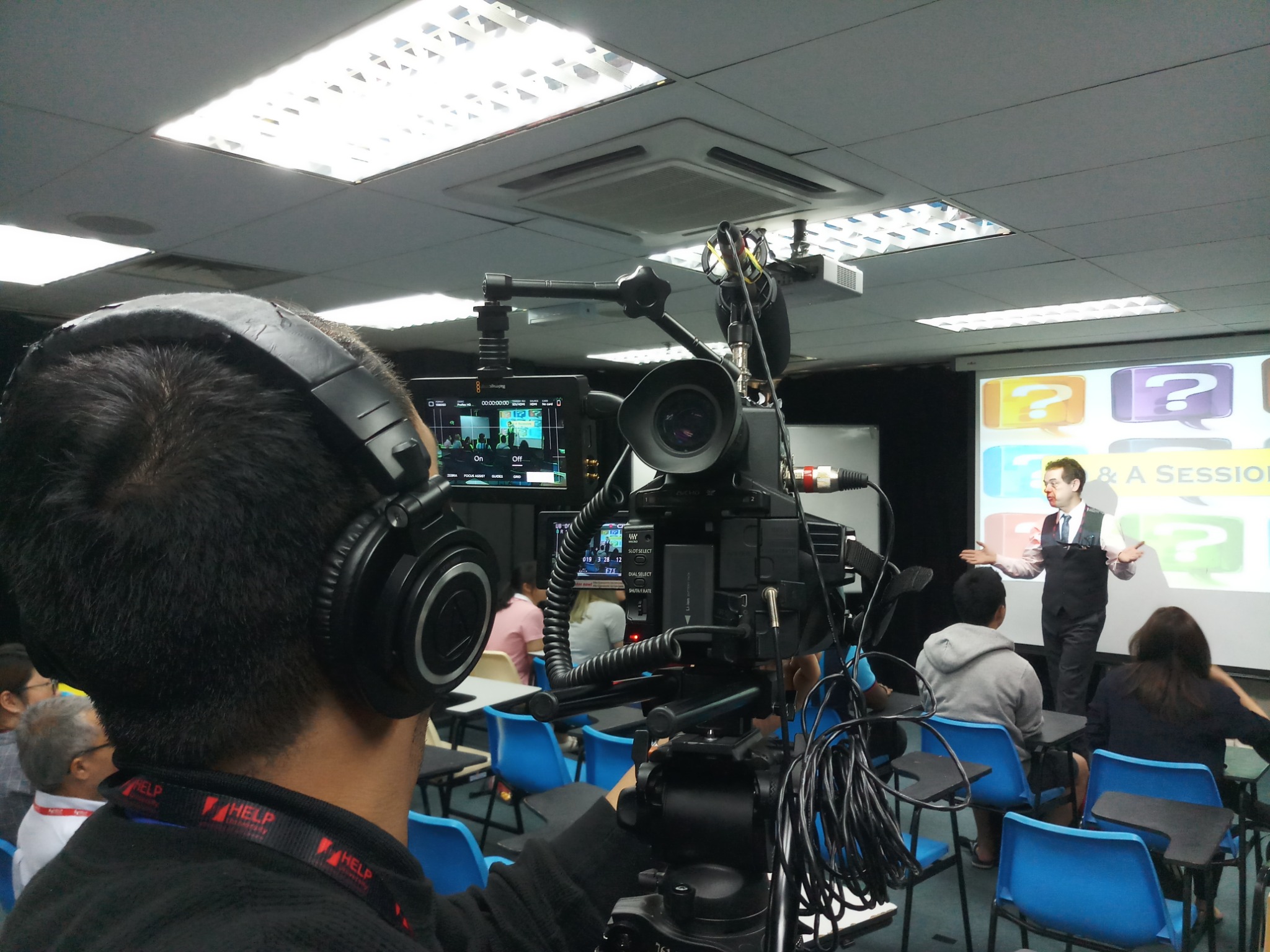 Filming a presentation attended by seated participants