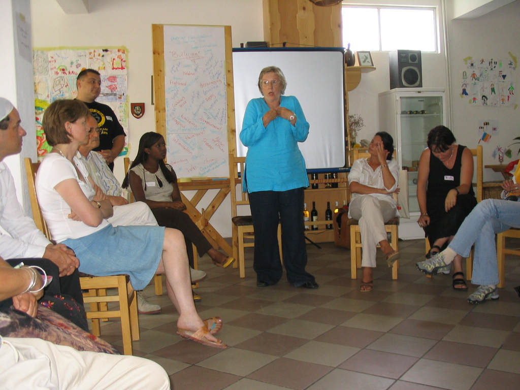 Sue speaking to a group of participants seated in a circle
