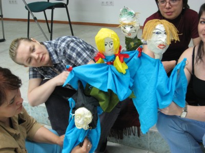 Workshop participants holding colourful handmade puppets