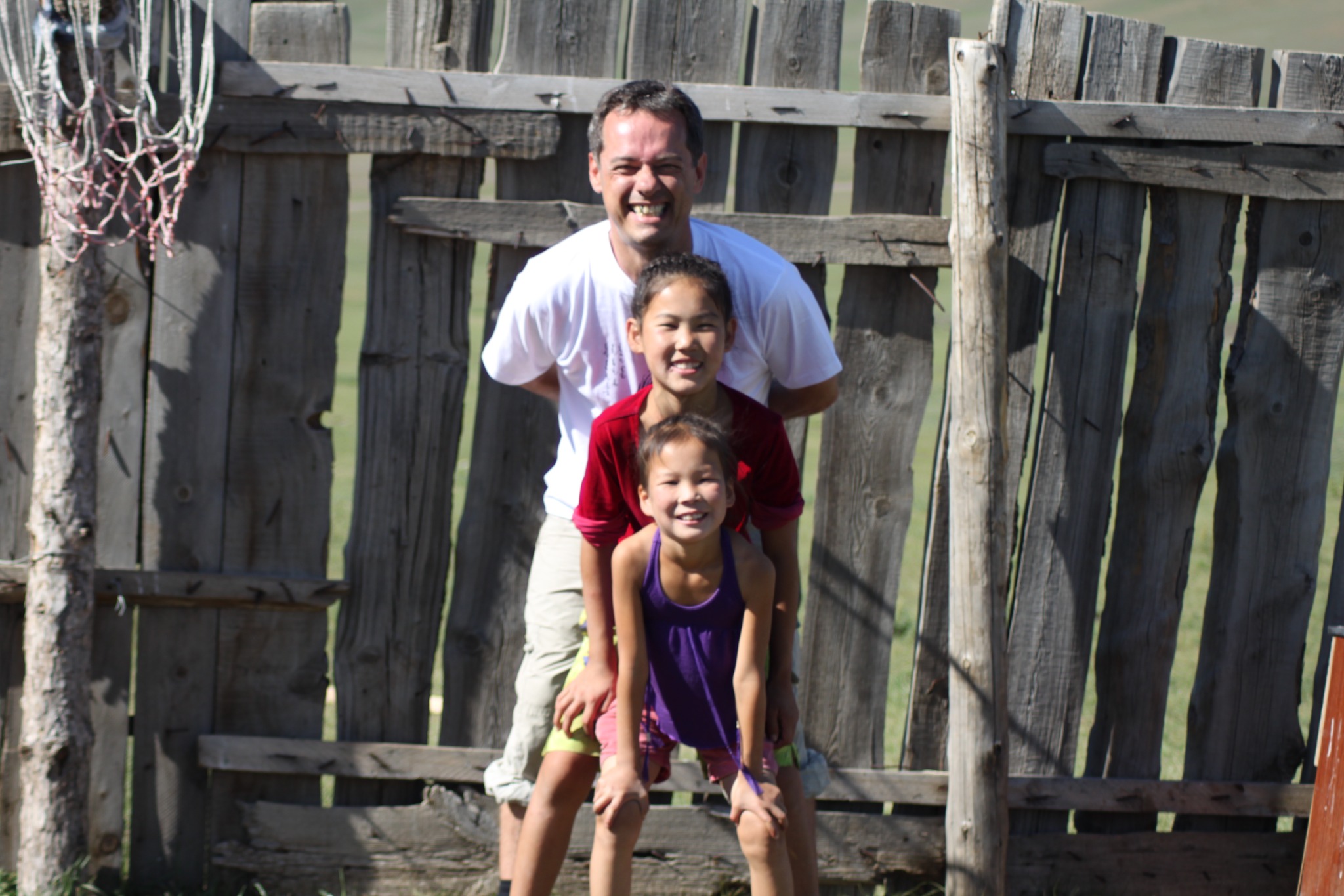 Andy smiling behind two younger participants outdoors