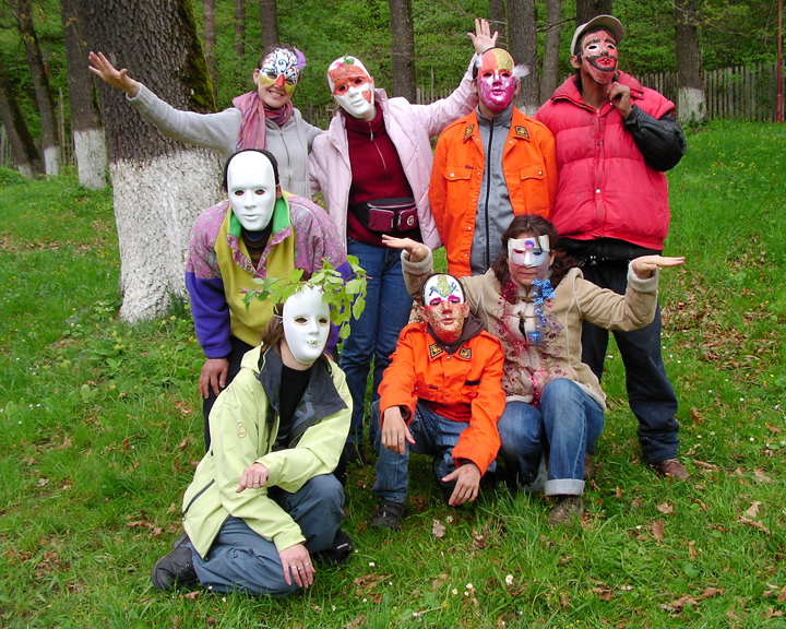A group of masked participants posing in a woodland setting