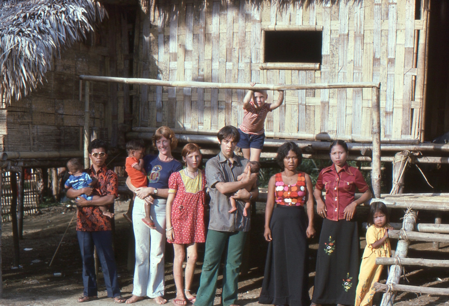 Sue with her three children and members of the Temiar community outside the family house in Kelantan in the 1970s